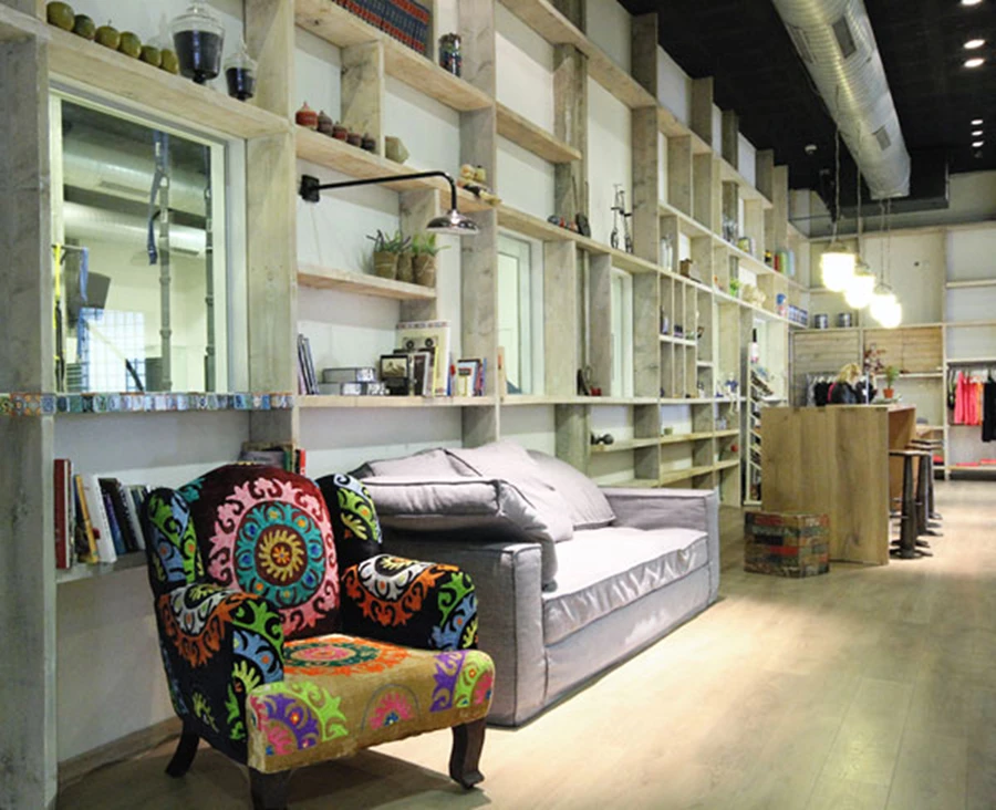 ספה להתרווחות נינוחה ,כורסה בריפוד ססגוני,ואריחים מצוירים המחפים את אדן העץ של פתח מזוגג