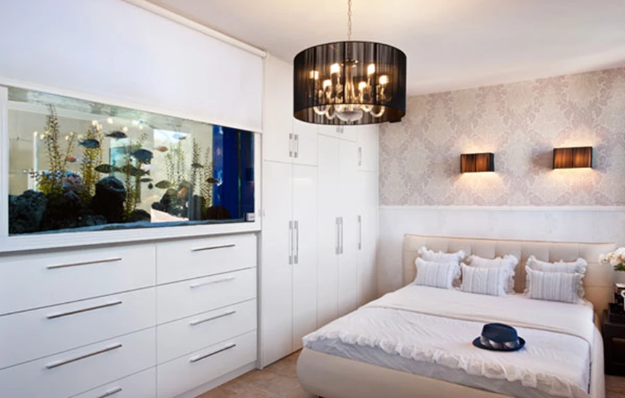 חדר השינה: הידור שקט בגוונים רכים לצד גופי תאורה שחורים הנוסכים ממד דרמטי כלשהו, ונוכחותו של האקווריום המשתלב בקיר ונוסך רוגע. וילון גלילה מאפשר להחשיך את האור המופץ ממנו בשעות הלילה.