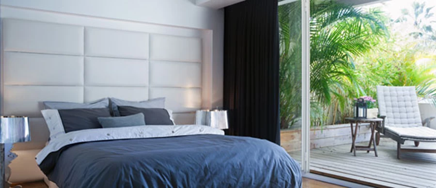 יחידת הורים: גב המיטה מרופד בתצורת ריבועים ונתון בתוך נישה ייעודית הממסגרת אותו כשבתוכה משתלבת תאורה.