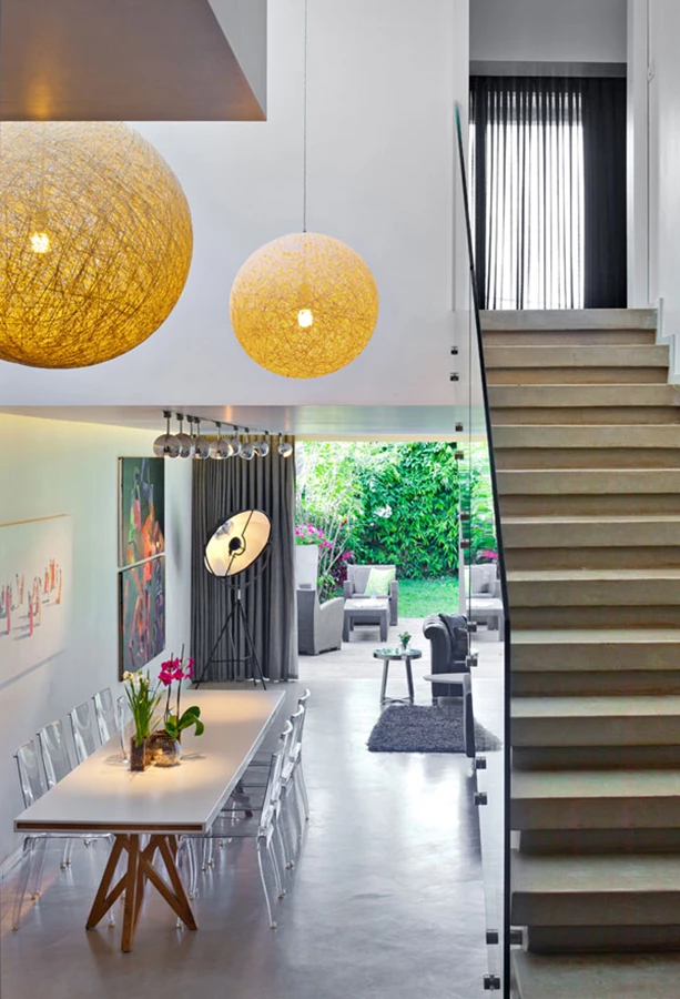 מבט מקדמת מפלס המגורים מעלה אל יחידת ההורים ומטה אל המרחב הציבורי. גופי התאורה כדוריים וגדולים המשתלשלים מרום התקרה באזור זה של החלל מדגישים את ממד גובהו ונוסכים עניין ויזואלי. גופי תאורה: