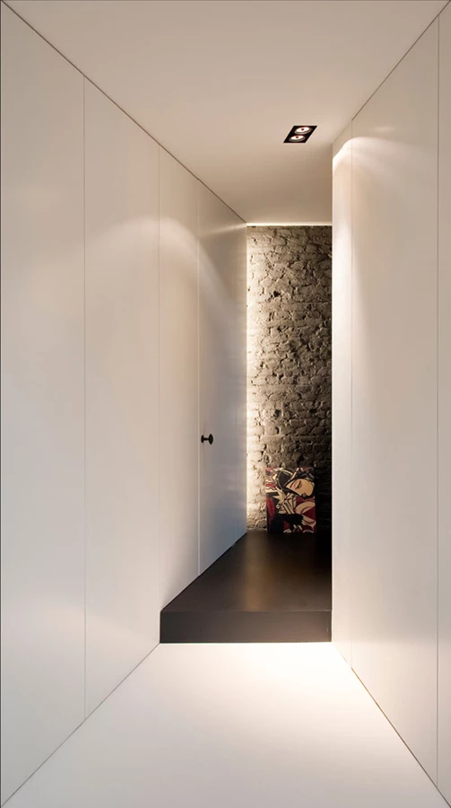 חלל מעבר בקומת הקרקע. ארונות אחסון מרצפה ועד תקרה מגדירים את דופנותיו