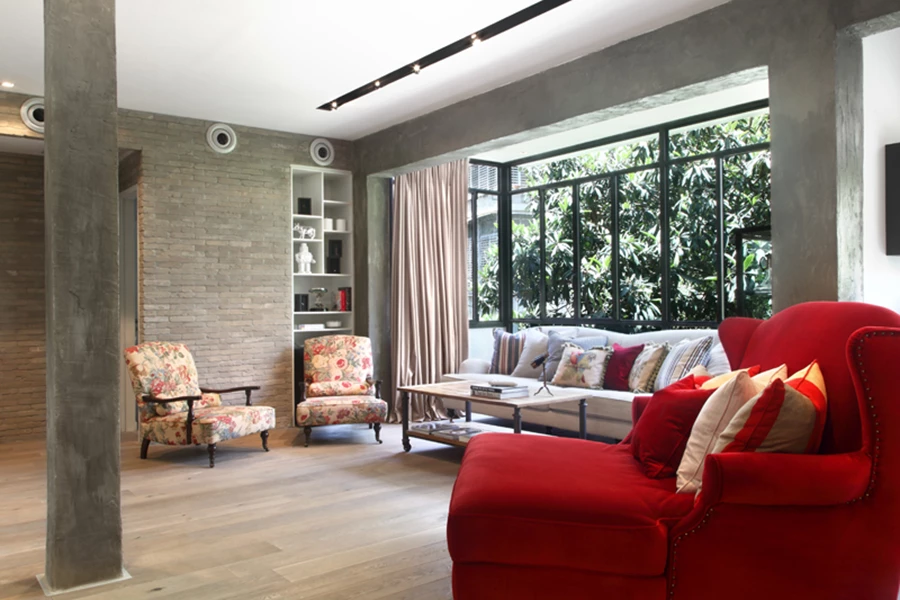 פינת הישיבה שבעומק החלל: קורות ועמודים קונסטרוקטיביים מודגשים באמצעות עיבוי והכהית הבטון ומנוצלים כמוקדים אסתטיים. מסגרות פרופיל אלומיניום בלגי בפתחים, לריצוף משמש פרקט אלון מגוון, וחיפוי קיר בלבני פירוק מדגיש את הארומה האירופאית כנקודת מיקוד של המארג העיצובי. פריטי ריהוט בסגנון קלאסי ושילוב טקסטילים בדיגומים וגוונים שונים. פריטי ריהוט: