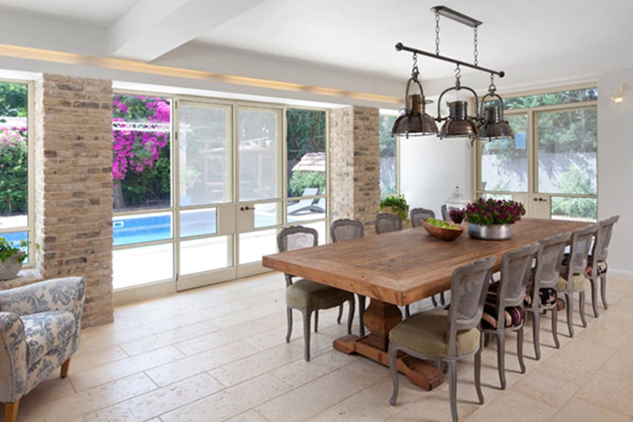 פינת האוכל משקיפה אל הגינה וממנה ישנה יציאה אליה. שולחן עץ מסיבי, כיסאות עם קליעה וינאית, וגוף תאורה שעוצב כחיבור שלושה פנסים תעשייתיים שפורקו ממפעל והותקנו על מוט. ריצוף: 