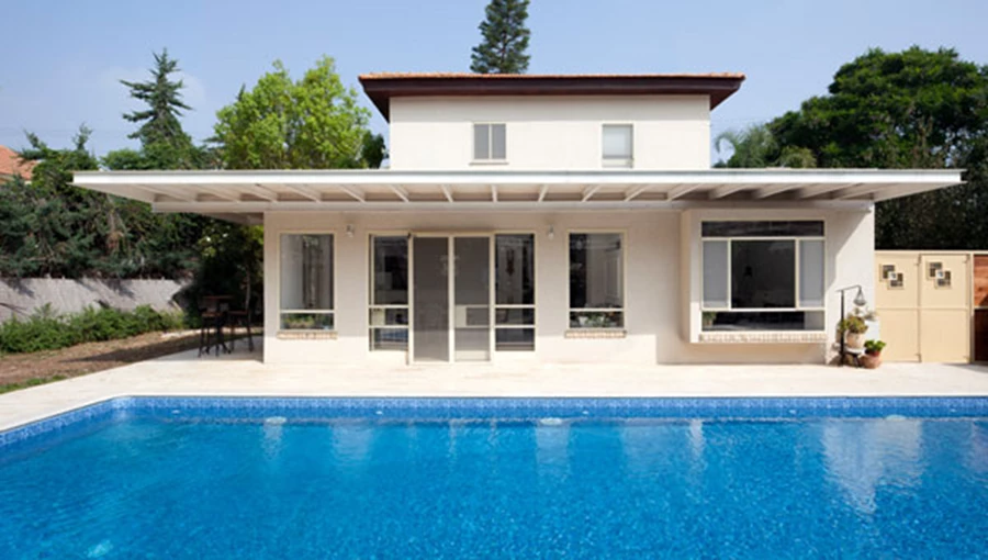 החזית האחורית: תוספת בנייה ששטחה ננגס מהגינה הרחיבה את שטח חלל הפנים וזיכתה את הקומה העליונה במרפסת המשקיפה עליה.