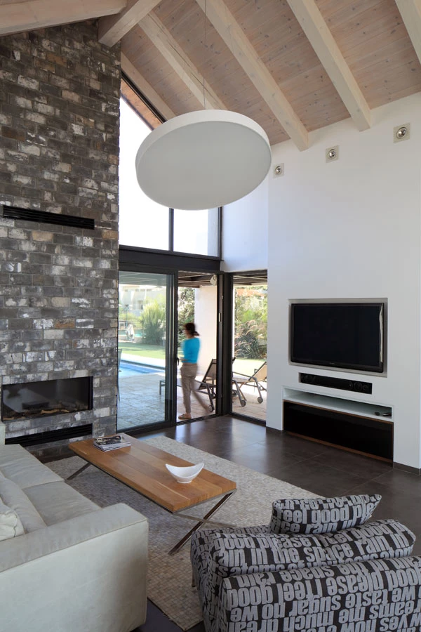 ארובת הקמין מחופה בלבני פירוק אפורות ומתנשאת עד מעבר לגובה הגג.