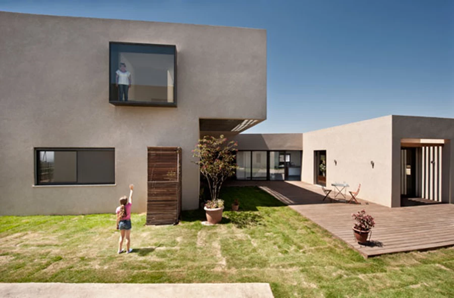 פתרון חלופי לנוף מגונן בחדר הרחצה: מערך מסתורי עץ מותקנים על מסגרת מתכת מייצר מרחב תחום לשילוב צמחייה ותחושת חוץ.