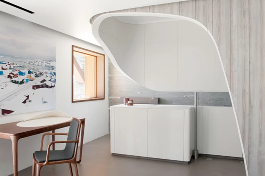 פינת אוכל הכוללת שולחן בתצורה פיסולית במרכז החלל ועשוי סטרוקטורת מתכת מצופה בבטון אשר עליה מונח משטח קוריאן.