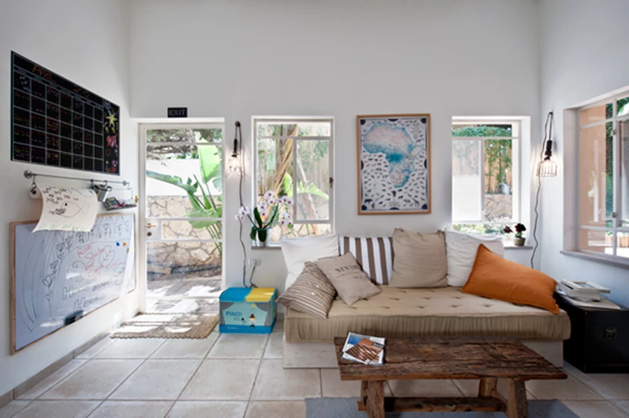 פינת המשפחה, הממוקמת בהמשך למטבח ועטופה בפתחים הפונים למבואה החיצונית של הבית. עיצוב נינוח מזמין 