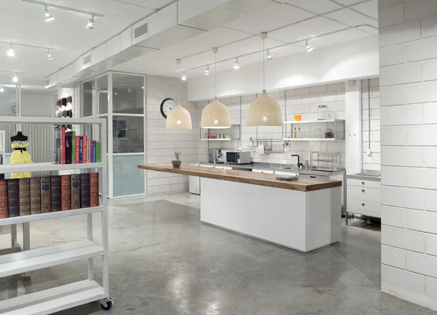 המטבח - ממוקם מול עמדות העבודה, מעברו השני של הציר הפתוח שחוצה את החלל. מעוצב בשפה מודרנית המשלבת פורמייקה ונירוסטה. משטחה של יחידת האי הגדולה עשוי עץ, והיא תוכננה כך שתוכל לשמש גם כשולחן נוח לישיבות צוות משותפות. שלושה אהילים גדולים מעליה מייצגים את הממד הביתי של העיצוב.