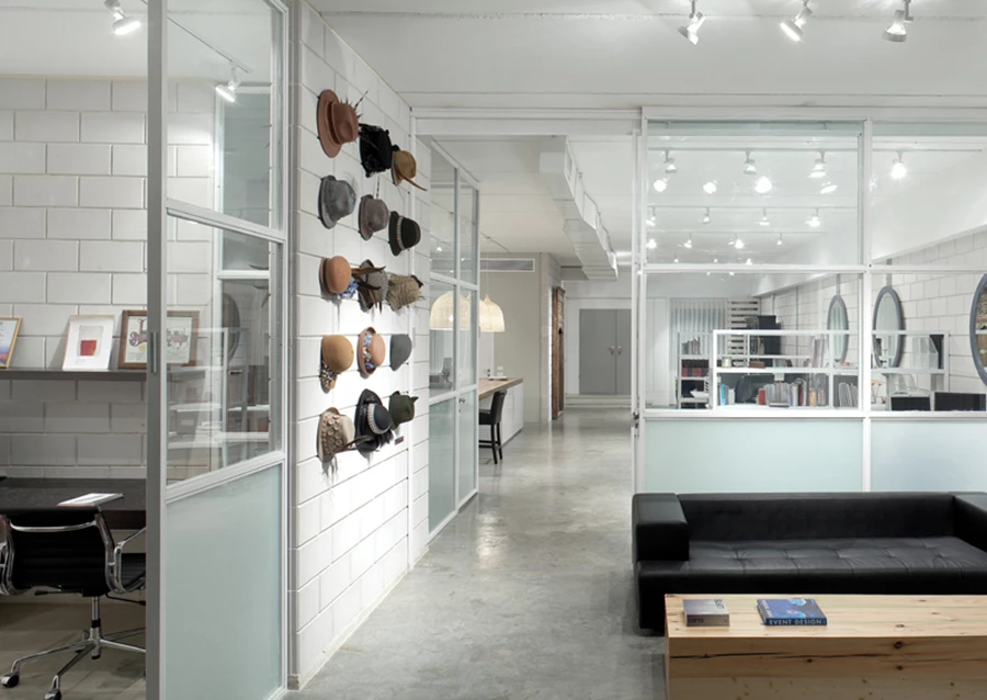 חדרי המנהלים שבעומק החלל: תחומים במחיצות זכוכית שאינן חוסמות את הזרימה הישירה. ושילוב דלתות הזזה בשטחם מאפשר לתחום את פינת הישיבה שבחדר לכדי חלל עצמאי ולייצר בעת הצורך חדר סגור לישיבות אינטימיות. אוסף כובעים שנתלה על הקיר הסמוך לכניסה אליהם תורם נופך “דקורטיבי” לא פורמאלי וממד אישי חינני.