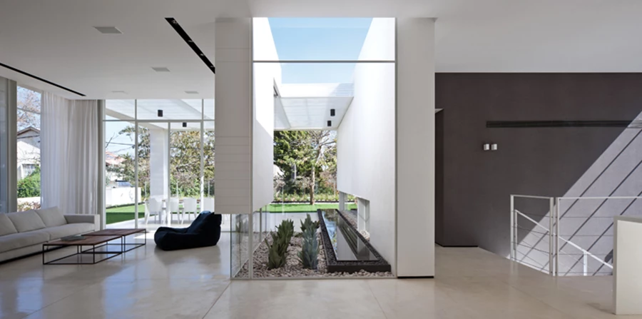 מבט מדלת הכניסה אל מרחב החלל: מארג נקי וקוהרנטי, וציר הבריכה מייצר שני אזורים הממוקמים משני עבריה. ריצוף בטון מוחלק בגון