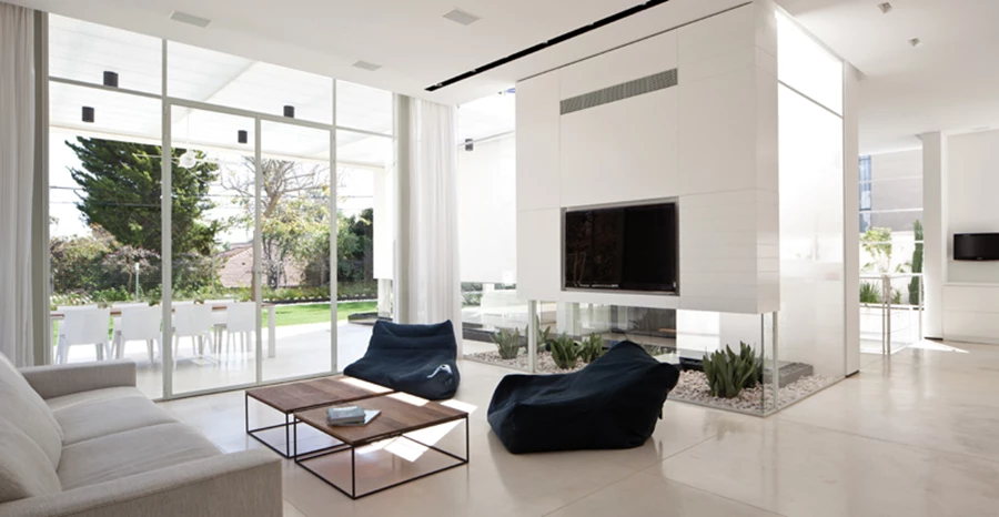 חלל הסלון: חובר לרחבת ישיבה חיצונית ומזמן הנאה ישירה וממוקדת מנופה של בריכת השיקוף. פתחי הסרט הנמוכים התקבלו הודות לתכנון קונסטרוקציה תלויה הנסמכת על קורות עליונות ועמודי ברזל במערכת החלונות, כך שהקירות האטומים נראים כתלויים ומרחפים באוויר, ללא כל תמיכה נראית לעין.