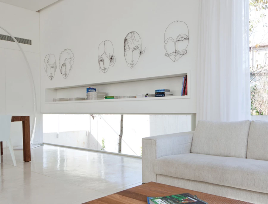 מבט מעומק החלל אל פינת האוכל הממוקמת בקדמתו, ואשר אף היא נהנית מפתח סרט נמוך החושף נוף מגונן. הקירות התמימים לכאורה, אינם אלא חזיתות נגרות הסוגרות על חללי אחסון ושירות, מצניעות מערכות תשתיות ואף כניסה לשירותי אורחים