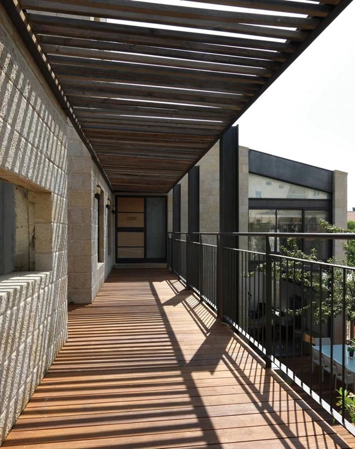 הגשר המקורה שתוכנן על מנת לחסוך שטח יקיר שנדרש למדרגות. בנוי כשילוב של עץ וקונסטרוקציית פלדה, וההליכה בו מזמנת תהליך הדרגתי של כניסה והיחשפות אל “מתחם” הבית.