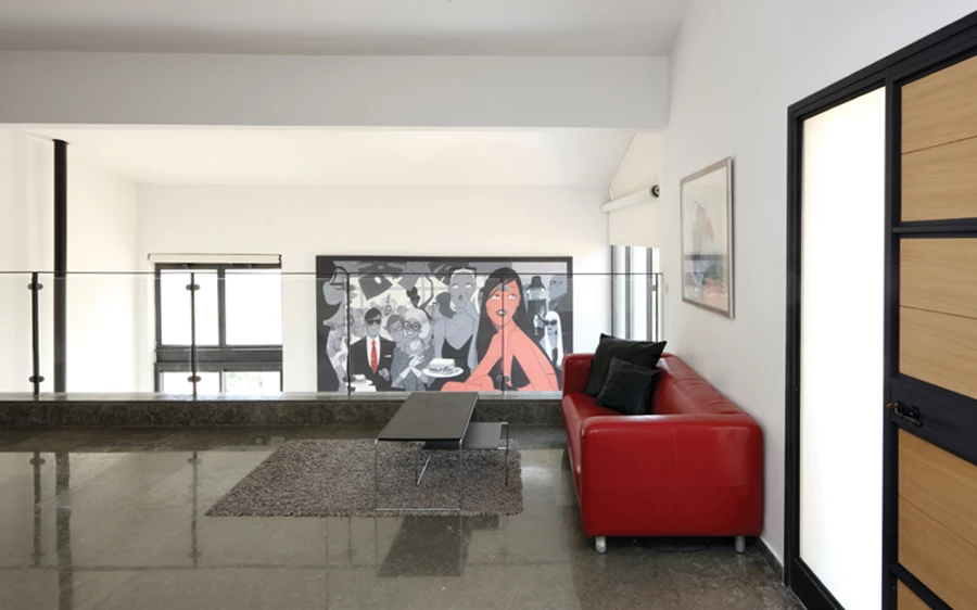 חלל המבואה שבקומת הכניסה: משמש אף כפינת טלוויזיה, ו”רוכב” מעל הסלון המצוי תחתיו כעין גלריה פתוחה, תוך קיום קשרי עין ישירים. המעקות השקופים, המשלבים זכוכית ופלדה, נוסכים שקיפות ואווריריות, ולריצוף משמשים אריחי אבן ביר זית שנבחרו ללא מיון, אך עברו תהליך ליטוש המקנה להם אחידות כלשהי.