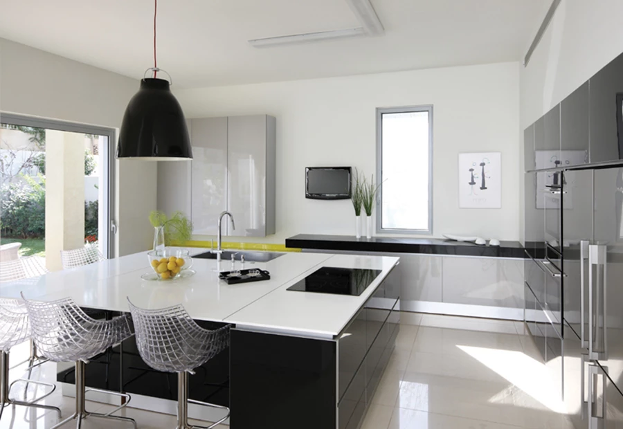 המטבח, שממנו ישנה יציאה ישירה לגינה האחורית: יחידת אי רבועה וגדולה במיוחד מאכלסת במשטחה העליון כיריים וכיור, משמשת כמשטח עבודה נוח, כמו גם כשולחן אוכל לכל דבר. גוף היחידה מכיל חללי אחסון ומשמש גם להצנעת תשתיות תוך הענקת נגישות נוחה אליהן.