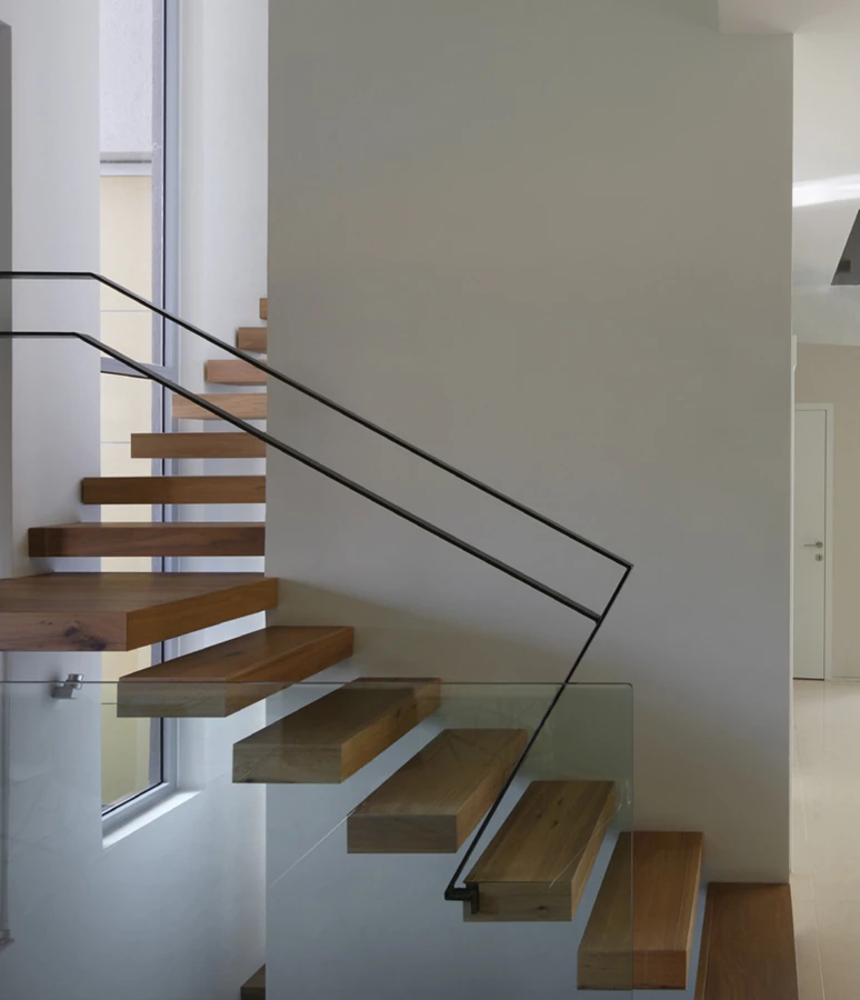 במרכז החלל - פיר מעלית ששולבה בבית מתוך חשיבה לעתיד, קושר את קומות הבית ואף מהווה “משען” לגרם מדרגות מרחף המשלב מדרכי עץ, מחיצת זכוכית ומאחז יד מברזל.