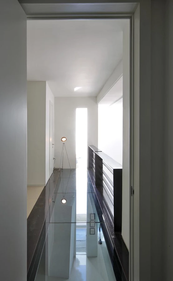 מבטים משני קצות הגשר. הגשר החוצה את החלל, ובקומה העליונה מהווה מעבר גלריה שמשני קצותיו ממוקמים חדרה של הבת ויחידת ההורים שלשטחה הוא חודר ומגדיר בה שני אזורים. הריצוף השקוף מעניק קשר עין ישיר לחלל המצוי תחתיו, והמתח המתקיים בינו לבין הברזל המסיבי של הקונסטרוקציה מייצר עניין ויזואלי.