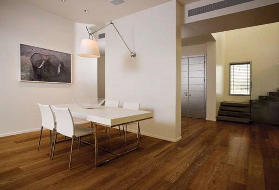 מבט מעומק החלל אל עבר דלת הכניסה. בצדו השני של הקיר המנותק ממוקמת פינת האוכל, ומימין נראה אזור החלל הכפול בו ממוקם גרם המדרגות