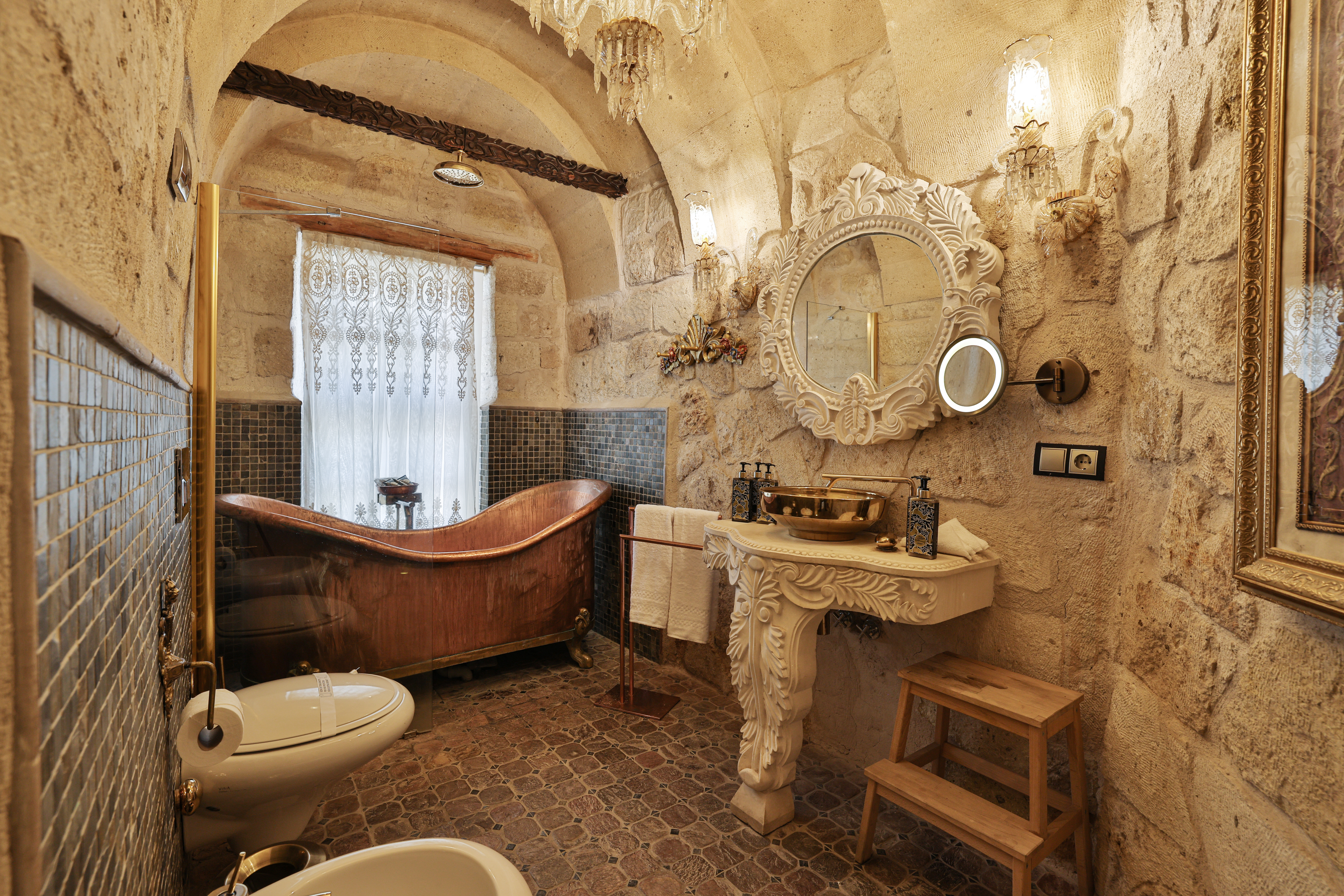סוויטת King Cave Junior עם בריכת טבילה ב־Elika Cave Suites Cappadocia, עם תקרת אבן מקושתת ופתח שמוביל אל אזור הבריכה. צילום © 2026 Hilton